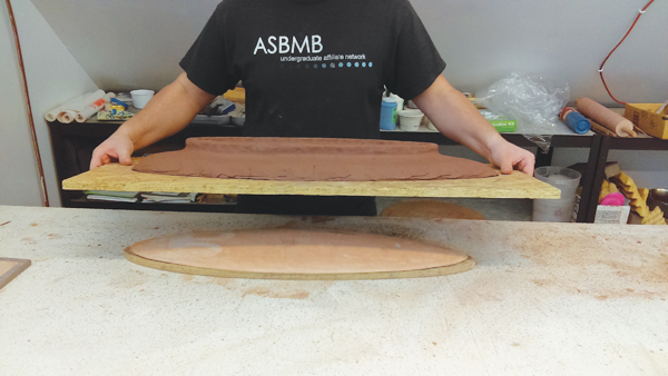 11 Lift the piece of plywood up to remove the tray from the bisque mold and set it aside until it reaches leather hard.
