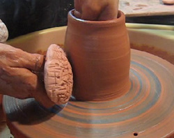 Potter Lisa Bare Culp demonstrates another method of altering soft thrown pots with bisque stamps.