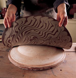 6. After sufficient drying (when the surface is no longer tacky to the touch) the slab is draped over a hump mold and pressed into place to form the dish.