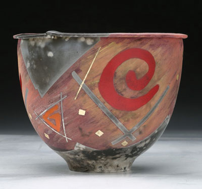 Steve Howell of Gainesville, Florida, uses a body made from half porcelain and half raku clay. After the initial bisque firing, he adds underglazes and bisque fires again. After the bisque, he places the piece upside down in a 2×4-foot brick pit in sawdust layered with copper carbonate, salt and bits of sticks and wood, then covered with a Kaowool blanket.