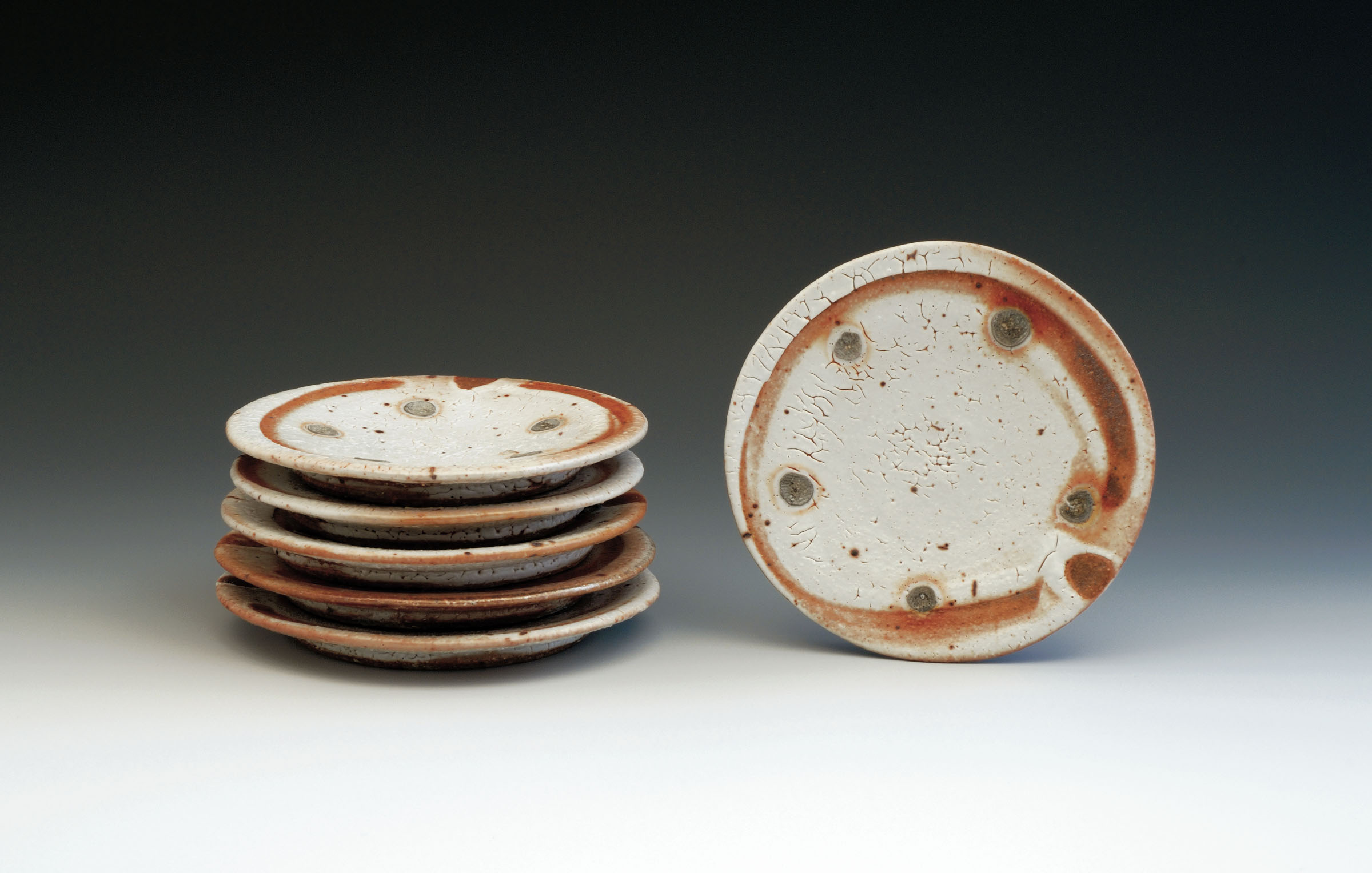 Set of plates, 7 in. (18 cm) in diameter, thrown stoneware with Shino glaze, fired in a stack to Cone 12, by Lisa Hammond, London, England.