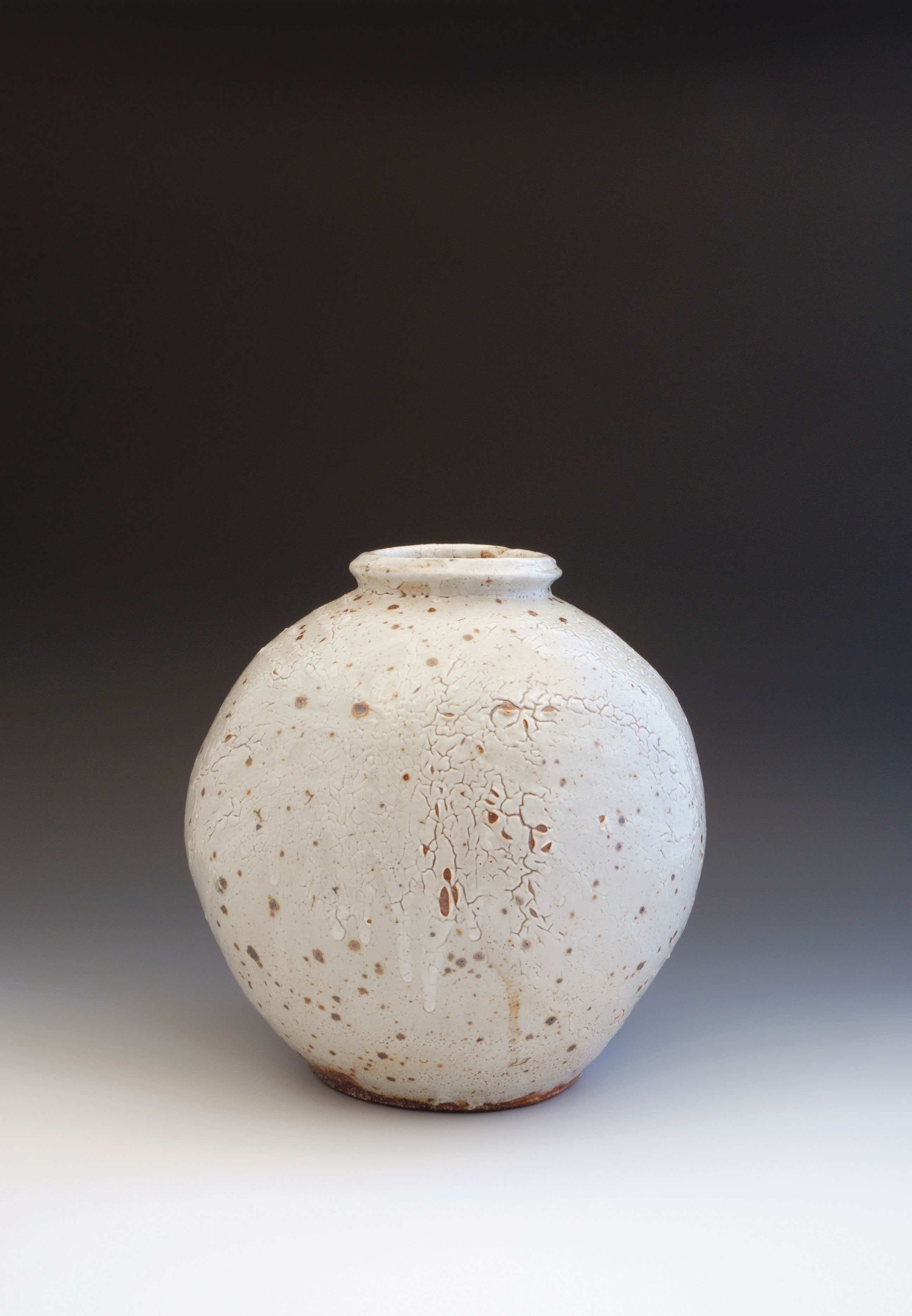 Round jar with iron spots, 12 in. (30 cm) in height, thrown stoneware with white Shino glaze, fired to Cone 9. Photos: Jay Goldmark, Andy Stewart