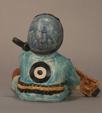 Back view of Babe in Arms, 9 in. (23 cm) in height, stoneware with stains, underglaze, and glaze, fired multiple times to cone 4, 04, 06, and 017, metal stand, 2007.