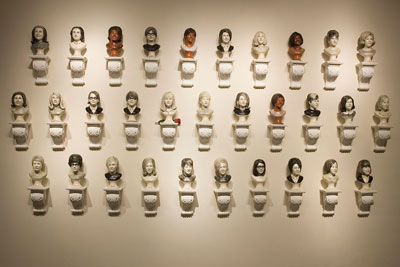 Detail of one wall of the installation, Good Girls 1968, showing the portraits arranged like the regimented representation of yearbook photo grids.