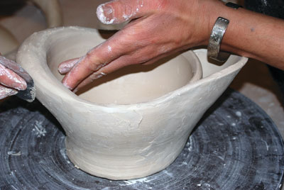 6. Compressing the clay while attaching the handle to the bowl.