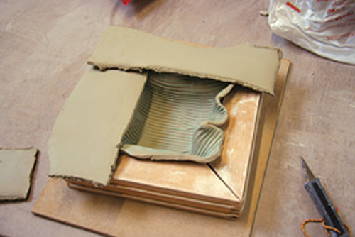 Ian Marsh constructs a dish by use of a wood frame. Soft slabs are overlapped.