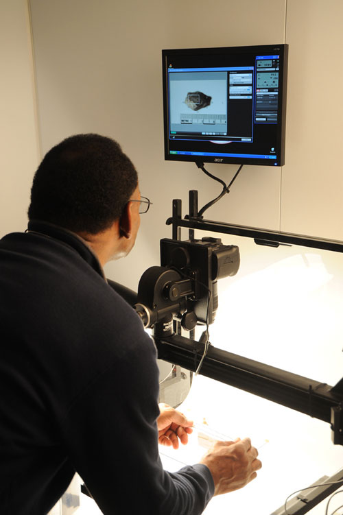 Army veteran Charles Liggins positions an artifact before he captures the image using forensic-level photography equipment. (Courtesy U.S. Army Corps of Engineers, Alan Dooley)