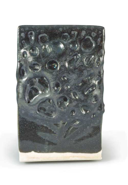 This test tile shows the bubbling of an immature oil spot glaze. As CO2 bubbles rise through the glaze, they deposit iron on the surface after they seal over.