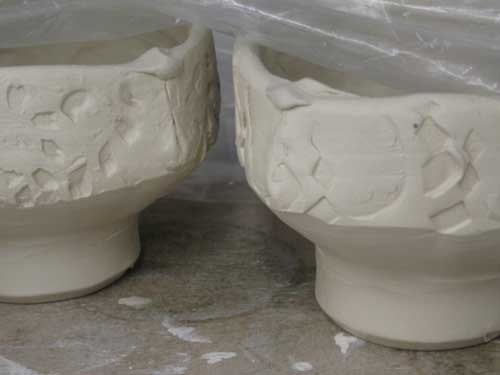 After the darted joints are reinforced with a coil of clay on the inside, the pots are covered and allowed to dry slowly until they are stiff leather hard. They are then dipped in slip and/or glaze and dried completely before being fired in a soda kiln.