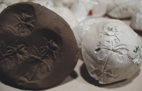 The plaster mold on the right was stamped into the soft clay on the left.