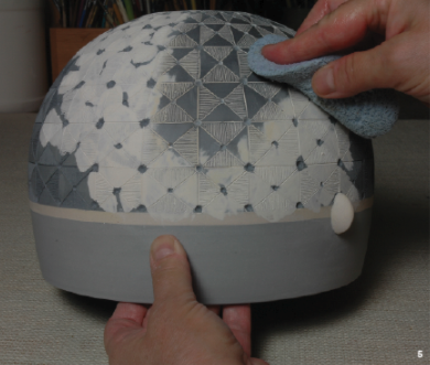 5 After bisque firing, terra sigillata or underglaze is painted over the incised areas and the excess is sponged away.