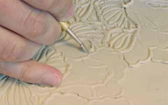 12 Carve perimeter and interior lines for each sprig petal. This adds definition and detail to the sprigs once they’re glazed.