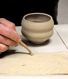 2 Use a wooden tool to make marks or a pattern in the slip that will transfer onto the surface of the leather-hard teabowl.