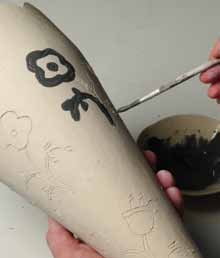 13 Paint over the carved drawings with black underglaze, or a color of your choice, being sure to fully fill in each line.