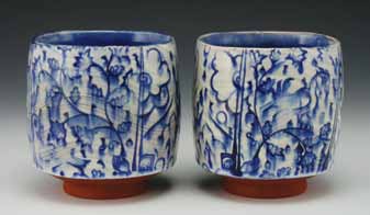 Blue and white yunomi, to 4 in. (10 cm) in height, earthenware, white slip, stamped pattern, glaze, fired to cone 2 in oxidation, 2014.