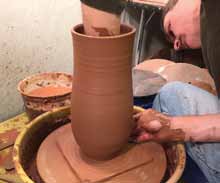 2 Throw a tall cylinder, shape the bottom with a wooden rib, and remove water from the inside.