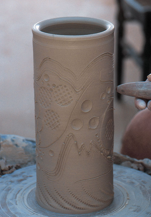 Throw a soft clay cylinder, clean the surface of residual slip, and impress with various tools.
