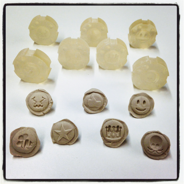 9 3-D printed plastic emoji designs with Emoji-Mon 7 clay sprigs.