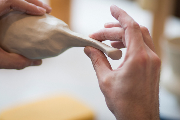 2 Slowly pinch and shape the clay along the lug toward what will become the top attachment. Cut the handle off the lug and adjust it to make sure it is symmetrical and the appropriate size.