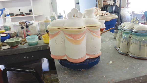 13 After bisque firing, draw a design onto the pot, brush on colored glaze made by mixing stains with frit and bentonite.