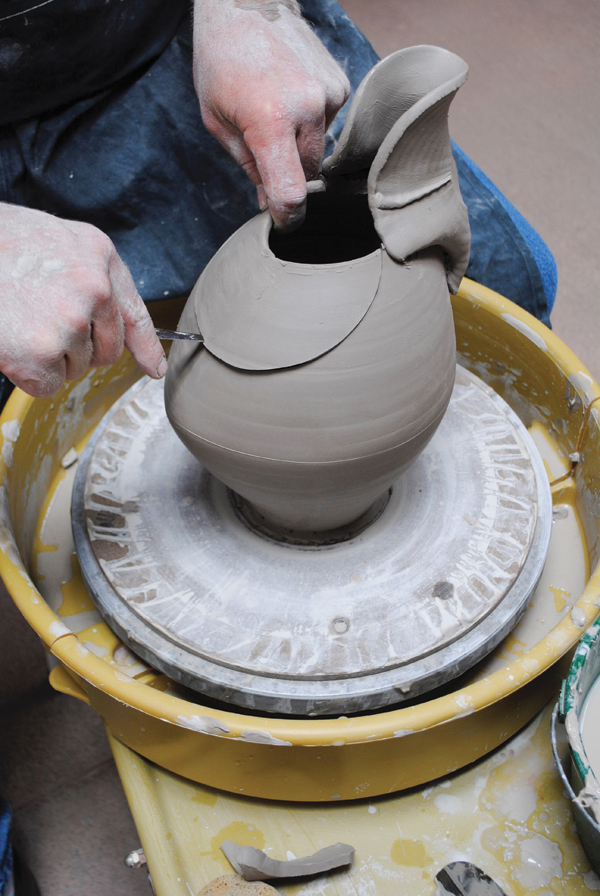 4 Cut a semicircular shape from the back of the pitcher to complement the spout shape and gesture.