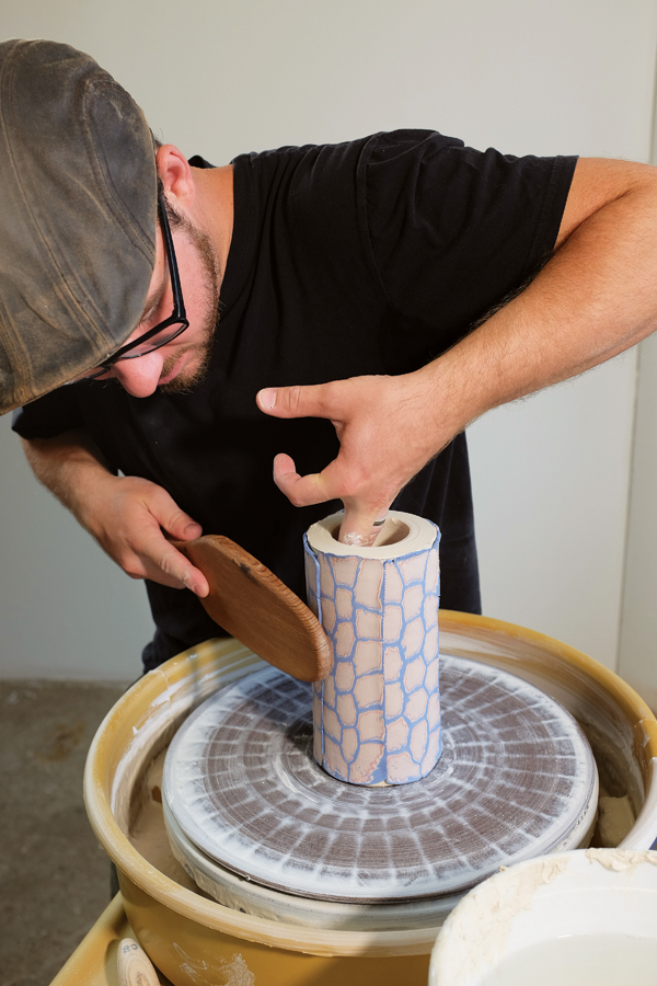 3 Applying the sliced cane to the outside of a thick thrown cylinder and paddling to ensure a secure attachment.