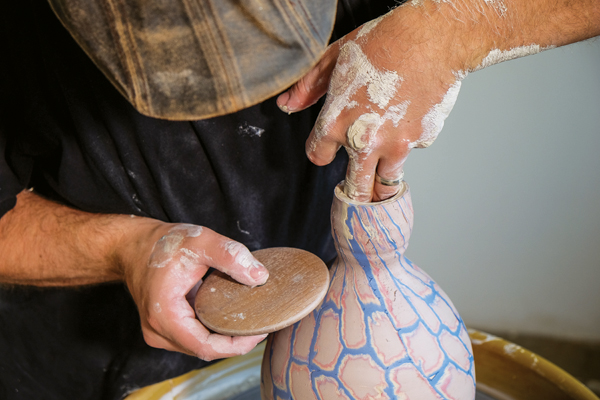 6 Finishing the vessel form using pressure from one hand inside the piece and pressing against it with wooden roller on the outside.