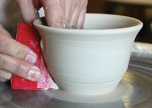 3 Push out against the rib to shape and clean the outside of the bowl. Use the rib’s curved top to make a laid-over rim.