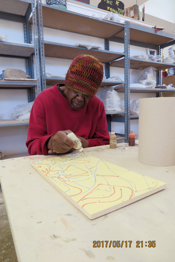 Cedric Johnson works on ceramic tiles for a private commission.