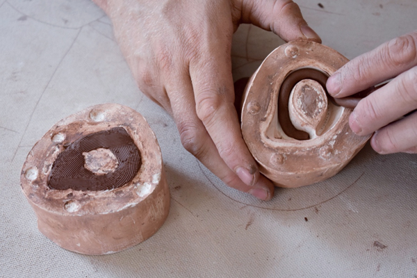 14 Press clay into the two-part handle mold, leaving it slightly elevated above the surface of the mold to aid in attachment. 
