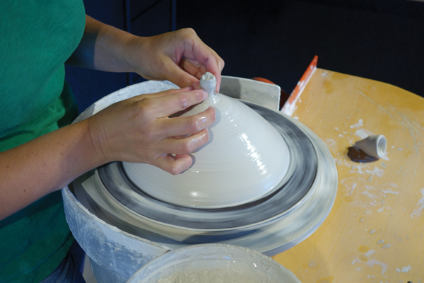3 Once the thrown form is fully closed at the top, use your fingers to pinch away any excess clay.