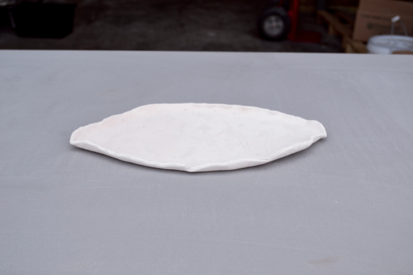3 Roll out a slab that is slightly larger than your pot to use as a waster slab, which will catch any possible glaze drips. Curl up the edges of the tray to catch any pooling glazes. Bisque fire your drip tray.