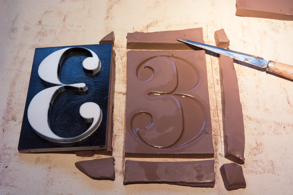 3 The stamped number tile created from a 3D-printed stamp (shown on the left). A release agent remains on the clay.