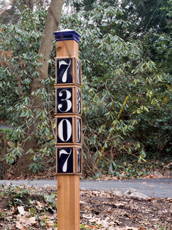 Tiles mounted on a post, shown in daylight and at night (top of post). The reflective paint provides a very visible, high-contrast sign.