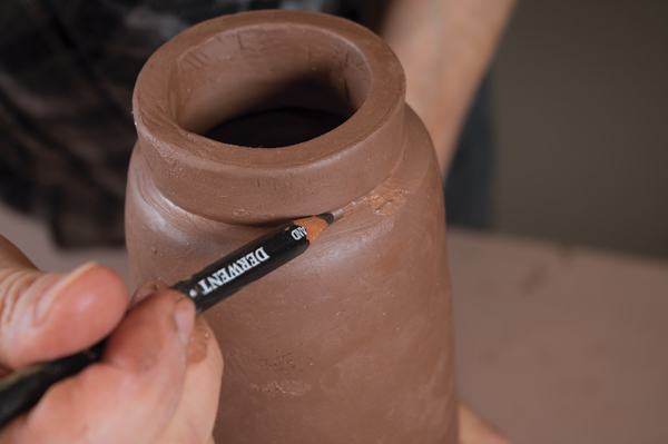 10 Add a strip of clay to the shoulder to create a neck for the bottle, then seal and clean up the join using a soft pencil lead.