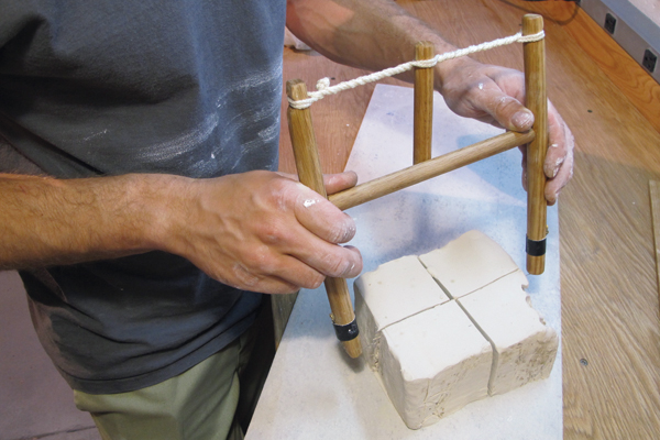 A Dividing a block of clay up into smaller sections.