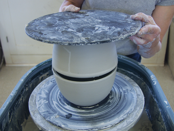 4 Score and slip both rims. Place the first bowl on the wheel, then invert the second one onto the first one.