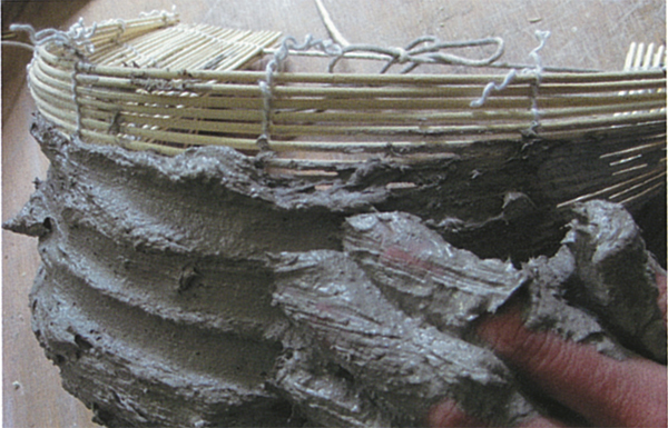 3 Applying the clay slip in layers on the bamboo blind. Each layer is left to dry before applying the next one.
