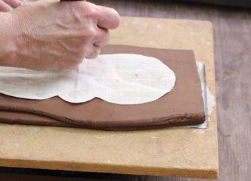 2 Place the paper template for the base on the two layered slabs. Use a knife to cut out the base with a slight angle.