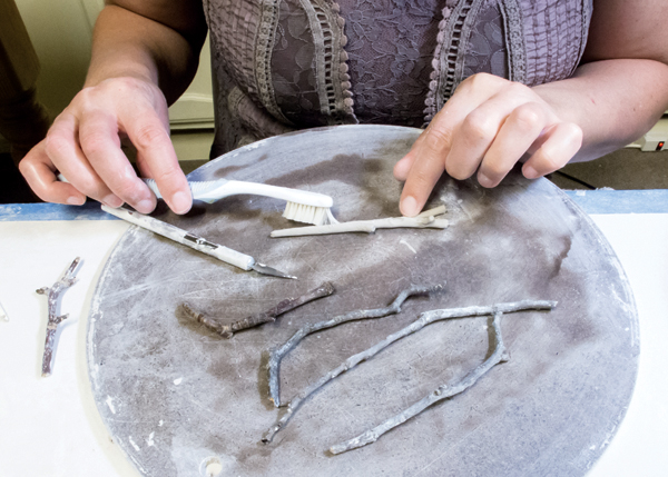 13 Use a toothbrush to add a natural woodgrain-like texture when forming a twig handle for the spoon.