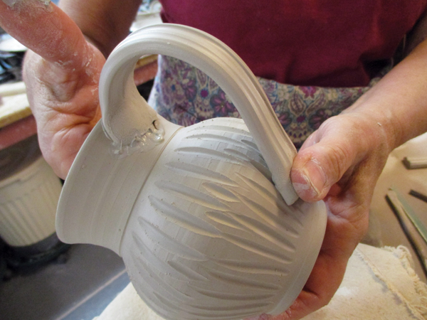 3 Score and slip the top of the mug before attaching the handle.