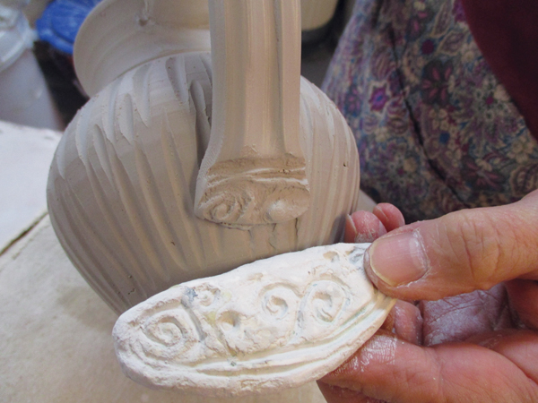 4 Embellish the base of the handle with a clay stamp or a carved design.