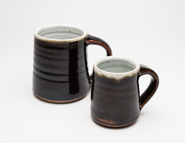 2 Standard Ware mugs created at Leach Pottery, stoneware, ash, dolomite, and tenmoku glazes, fired to 2336°F (1280°C). Photo: Sarah White.