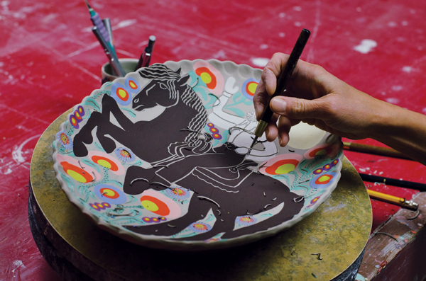 4 Carving through the underglaze to add linear details to the figure, horse, and flowers prior to applying smaller areas of color.