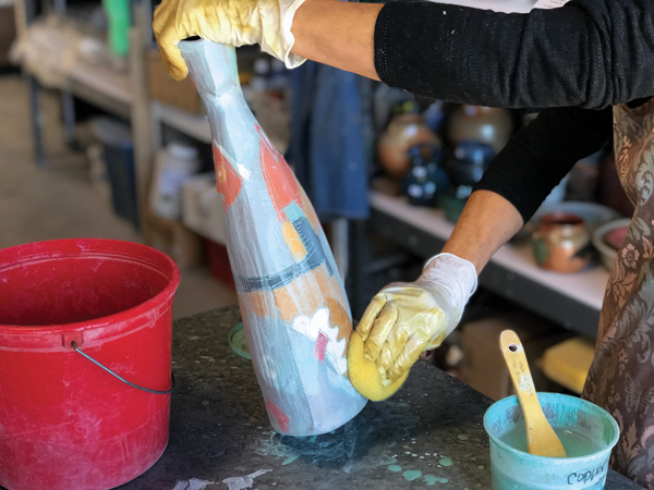 16 Wipe off the copper carbonate wash with a sponge and water. Enough will be left in the sgraffitoed lines to darken them once the piece is fired again.