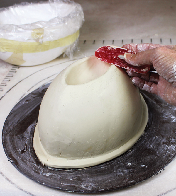 13 Replace the bat and turn the mold over. Take the mold off. Cut off the excess jagged edges of clay and smooth with a rib.