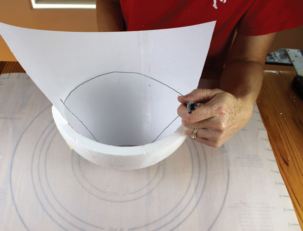 5 Make a template for your clay slabs by stretching paper along one complete side of the mold. Mark where the paper meets the edges of the mold side and cut out the template. Put the template back in the mold and make sure that it fits.