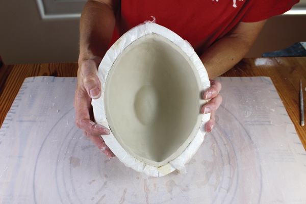 15 I like to place the bowl back in the mold to dry. This way I can check the inside of the dimpled bottom readjusting as necessary. I can also make sure the rim is still oval and has not misshapen.