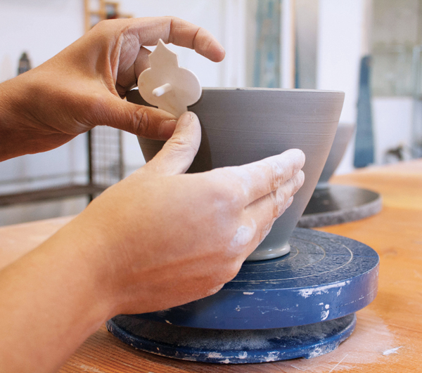 4 Begin to add a stamped pattern to the pot, using the largest stamp and starting at the rim.