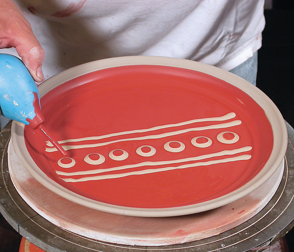 1 Dotting a colored casting-slip pattern using a slip trailer.